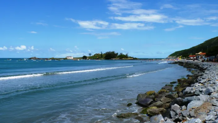 Mar calmo de la playa de Armação y la isla de las Campanhas, unida a la costa por un camino de piedras